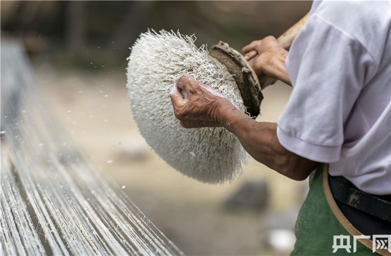 李爱牙师傅正在使用传统工艺加工制作夏布 (央广网发 赵春亮摄)