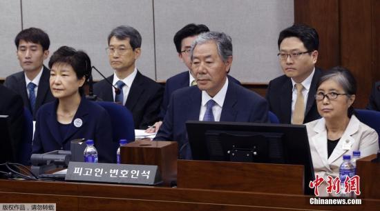 资料图：朴槿惠与崔顺实共同坐上被告席。