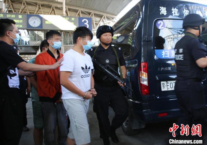 图为警方押解犯罪嫌疑人. 张扩 摄