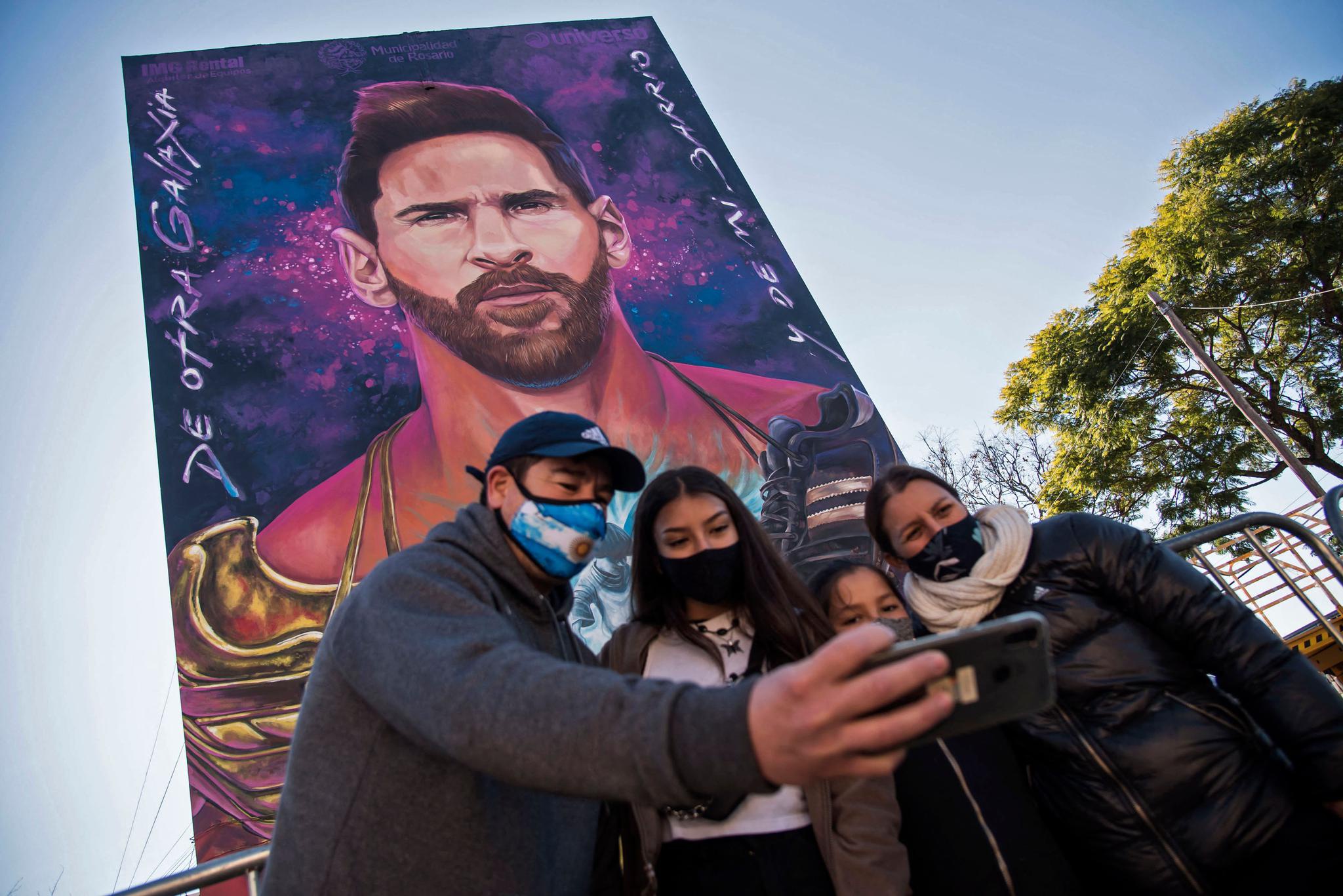 阿根廷球迷在梅西壁画下自拍。