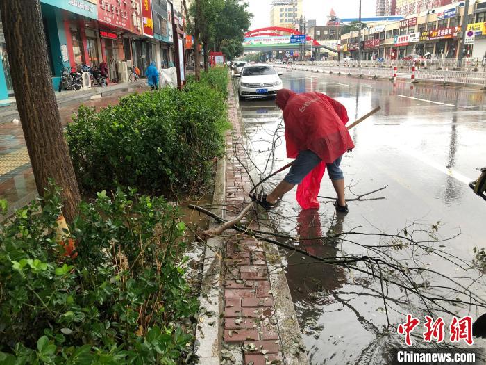 图为易县住建局工作人员对雨后的街道进行清理维护。刘敬 摄