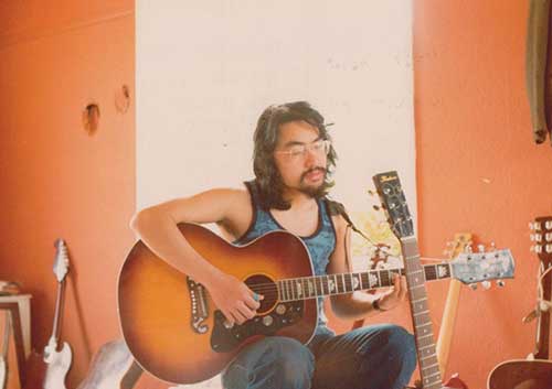 年轻时谈吉他的石黑一雄，摄于1977年。图片来源：nobelprize.org