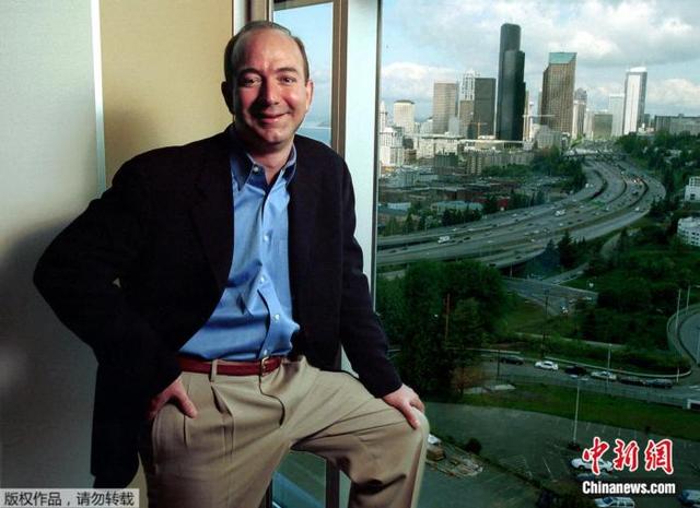 资料图：2001年5月2日，贝佐斯站在亚马逊公司的办公室里，身后是西雅图的高楼群。