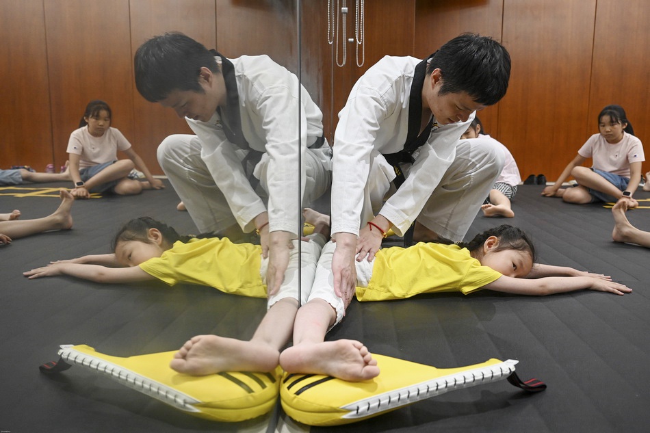 今年8岁的沈歆淇,3岁开始练习舞蹈,跆拳道课上的压腿练习对她来说轻而