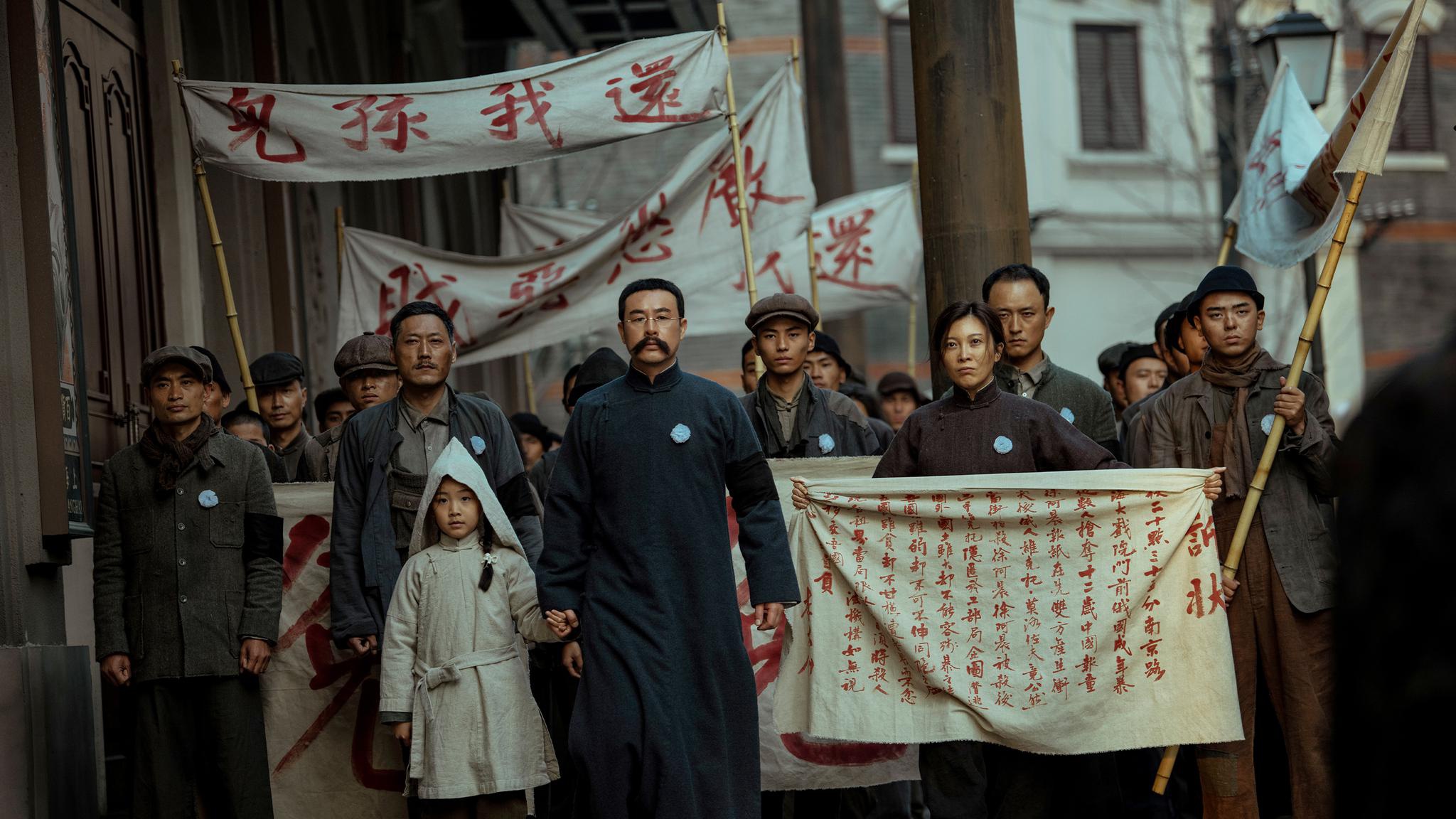 《革命者》剧照。李大钊带领着工人群众们在街上游行，抗议外国人枪杀无辜报童。