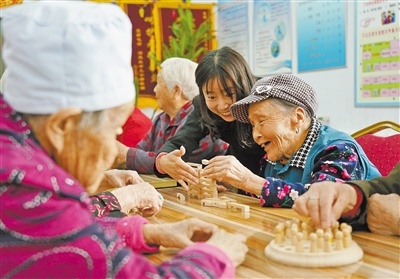 街道气象后街社区,阳光家园托养中心工作人员在陪老人玩益智游戏