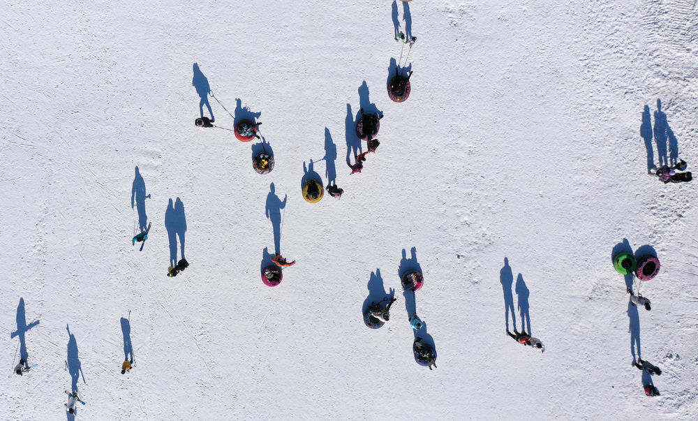  ↑2021年12月5日，游客在宁夏银川市鸣翠湖滑雪场体验雪上运动（无人机照片）。