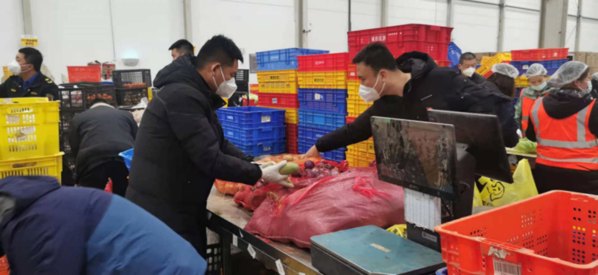 政府工作人员和美团优选员工在大仓内连夜分拣物资 摄影人:高飞