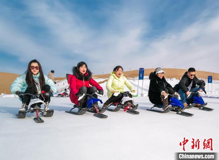 图为新年伊始，游客在敦煌沙漠露营基地享受滑雪的乐趣。张晓亮 摄