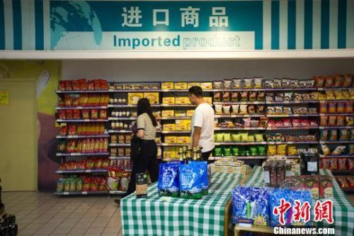 民众在超市进口商品货架前选购商品。张云 摄