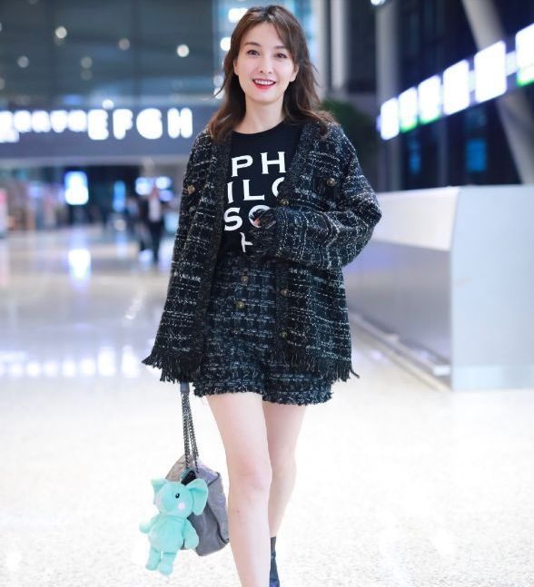 手提大象灰的包包,还在包包上别着一个大象玩具,为