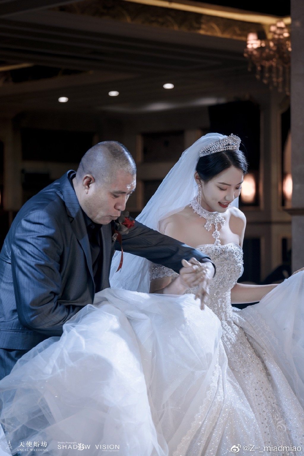 从照片可以看到,周淼穿着白色的婚纱,被家长搀扶着走进婚礼现场,在