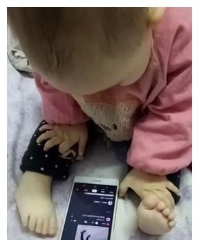 萌娃真聪明，手机放在床上用脚玩，这么小就会偷懒享受了休闲区蓝鸢梦想 - Www.slyday.coM