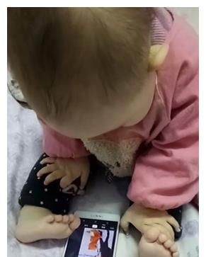 萌娃真聪明，手机放在床上用脚玩，这么小就会偷懒享受了休闲区蓝鸢梦想 - Www.slyday.coM