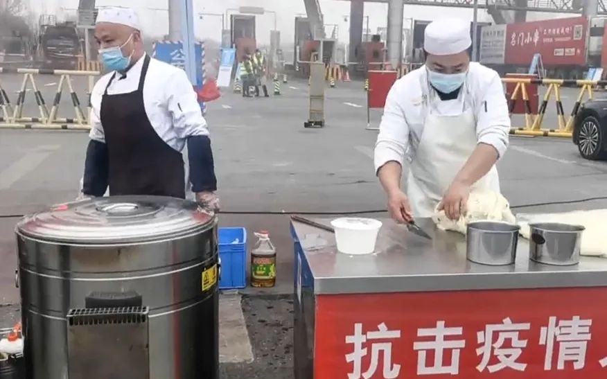 ▲1月10日，杨记拉面新城路店的厨师们在核酸检测点旁做拉面。 受访者供图