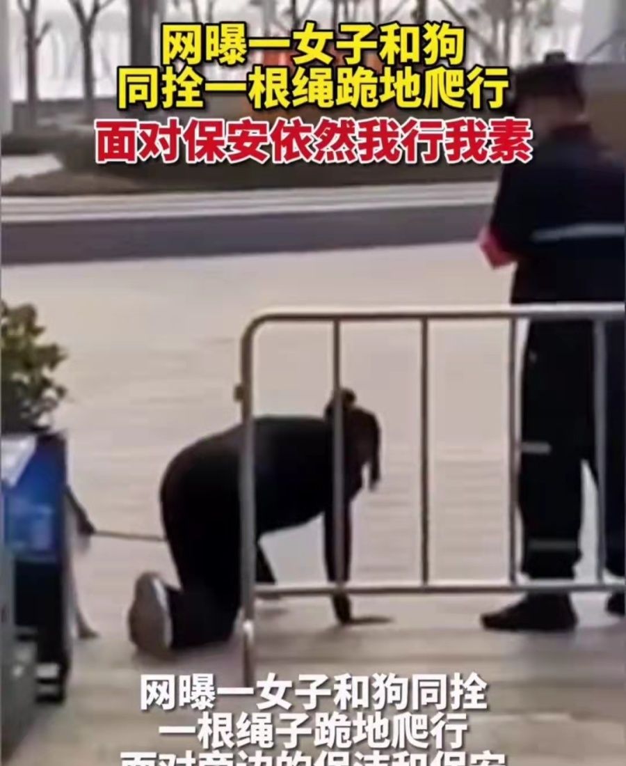 广东：女子脖子上拴着狗绳，跪在地上与爱犬一起在马路上爬行休闲区蓝鸢梦想 - Www.slyday.coM