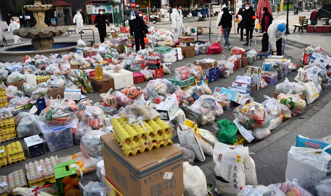 1月12日，下沉干部和志愿者在社区门前小广场准备配送生活物资。新华社 图