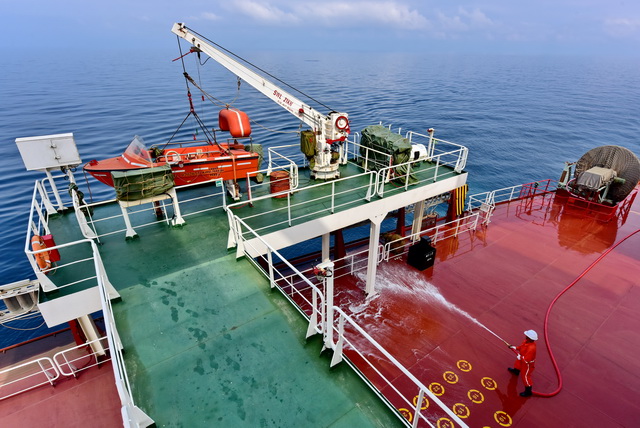 山东海运"山东人和"号货轮海员们在冲洗甲板.摄影/章轲