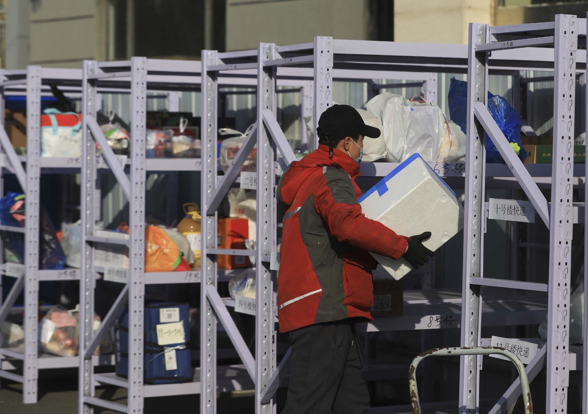 快递员根据楼号把包裹放在相应货架上.新京报记者&nbsp;浦峰&nbsp;摄