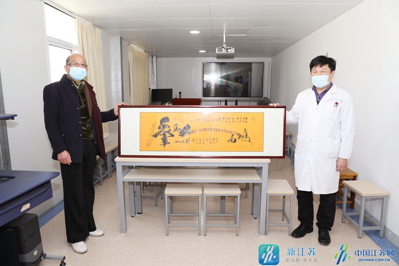 图为杨金生先生向高增鑫主任医师(右)赠送表达谢意的"心经"书法作品