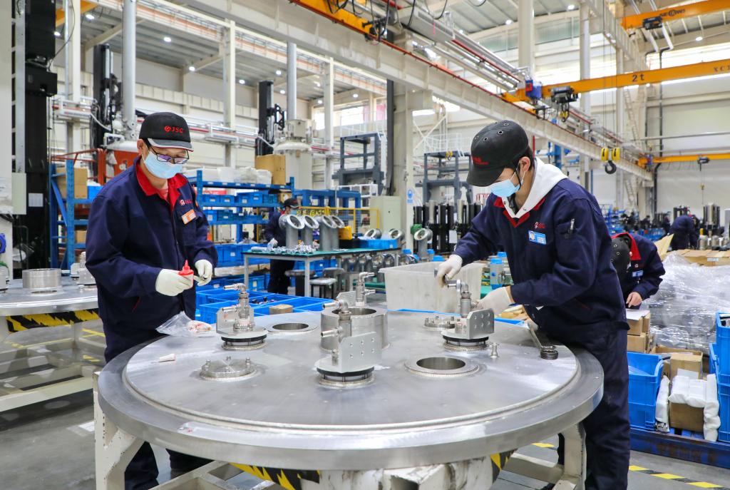 浙江晶盛机电股份有限公司车间内工作人员正在调试机器.