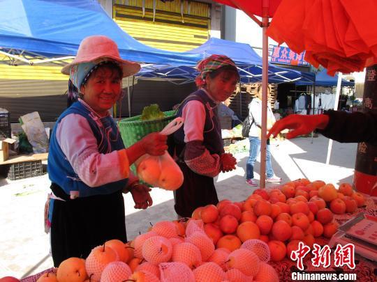 资料图：村民在乡街购买水果。　张丹 摄