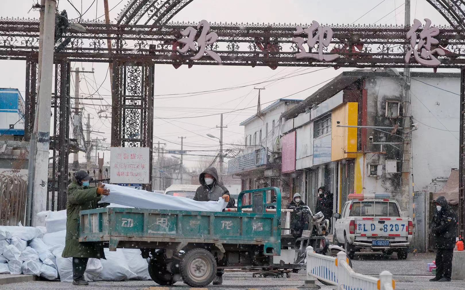 石各庄村北门，工作人员在搬运物资。新京报记者 王子诚 摄