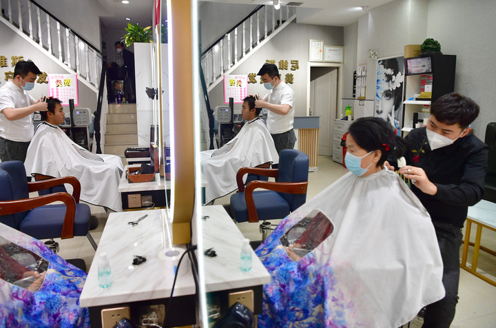 1月20日，在西安曲江新区一家理发店内，理发师正在为市民理发。新华社记者邵瑞摄