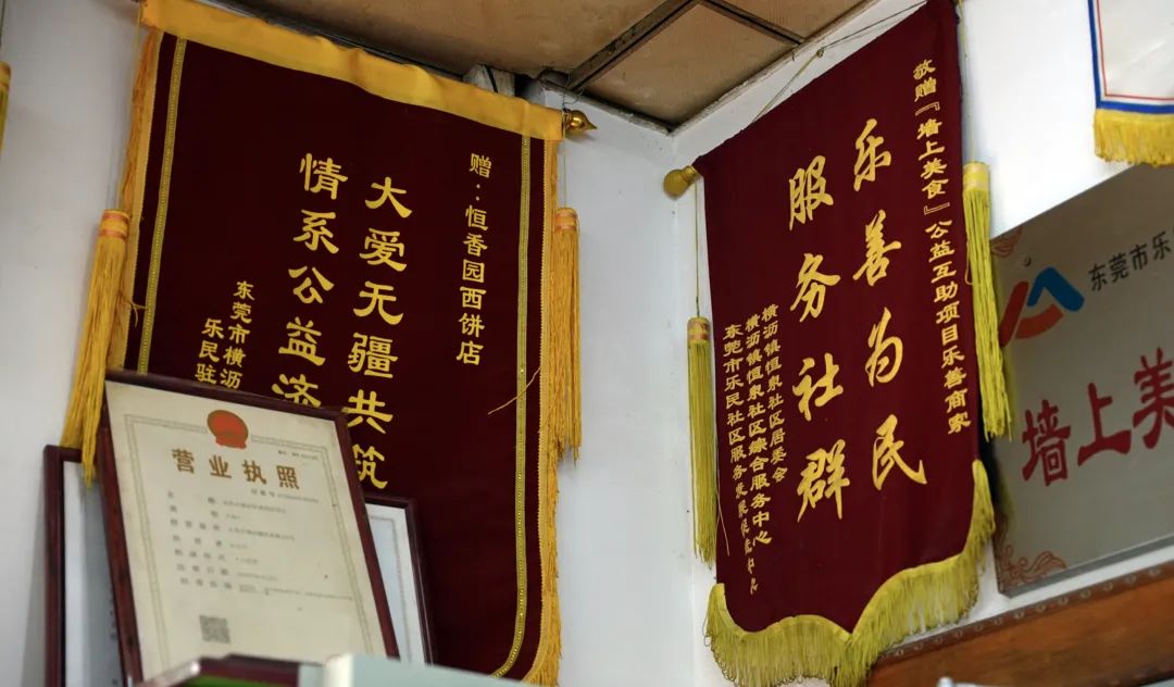 店内装饰简单朴素,门口正上方挂了许多面锦旗,有"关爱困难群体 热心