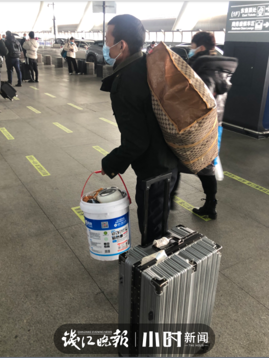 杭州火车东站归乡心切的行人提着的桶里装着啥有鞋子有杯子还有说不完