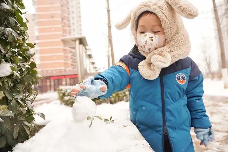 ▲小红门，一位小朋友在堆雪人。