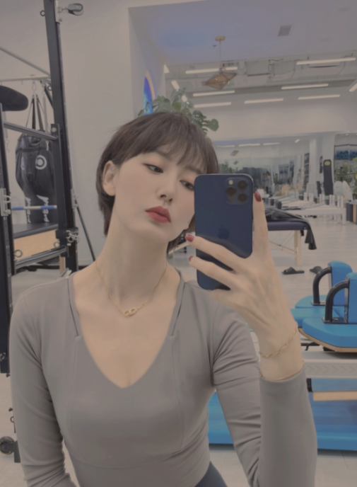 照片中,郭晓敏身穿灰色紧身上衣搭配黑色裤子,挑战高难度的高空劈叉