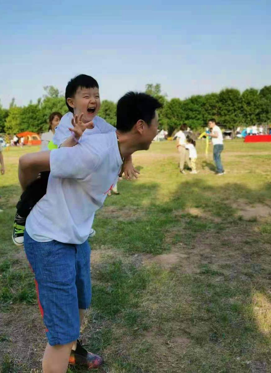 (这张照片中是我的儿子背着我的小孙子在玩骑马打仗.