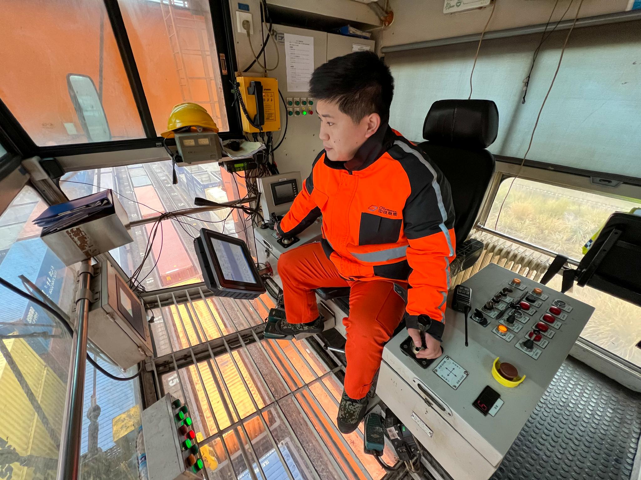 郑雨双在司机室内操纵龙门吊起吊集装箱(1月22日摄).