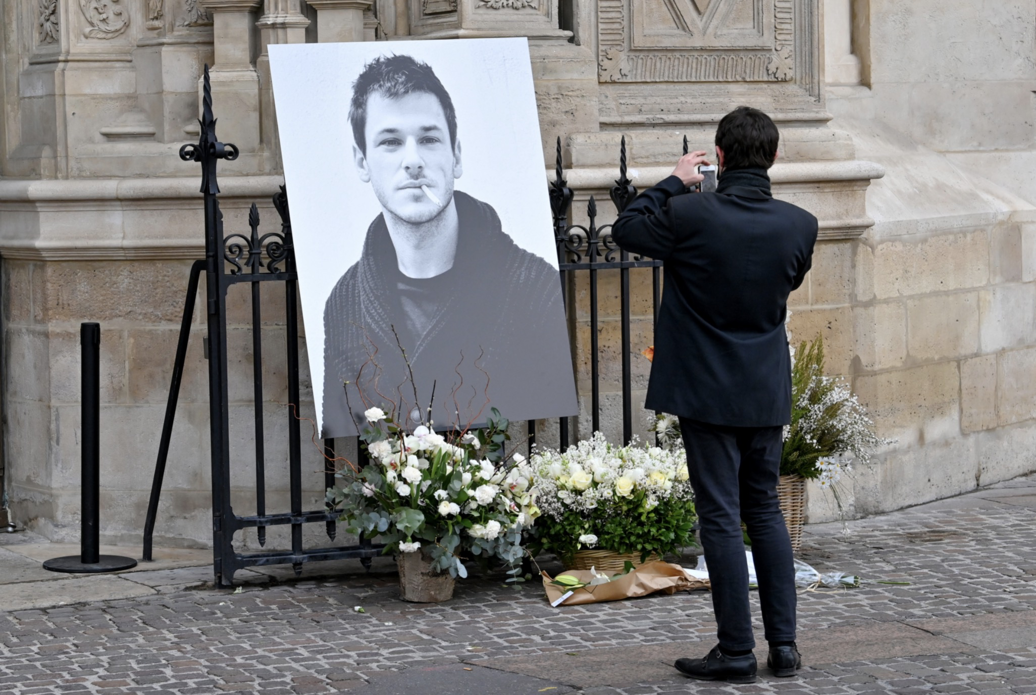 在葬礼教堂的入口处,有一张尤利尔的巨幅黑白照片,他的嘴里叼着香烟