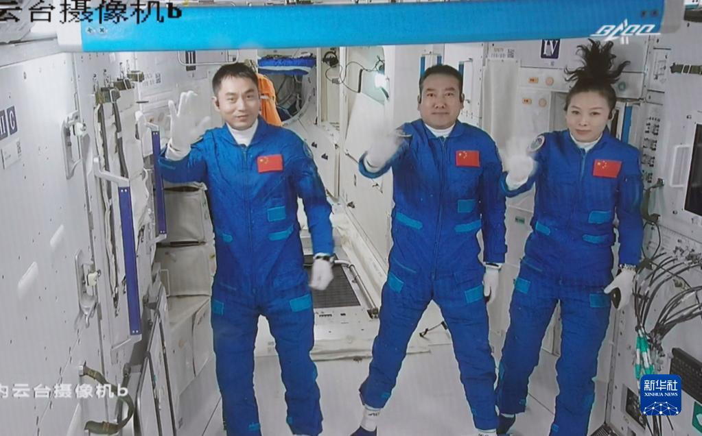 2021年10月16日在北京航天飞行控制中心拍摄的进驻天和核心舱的航天员翟志刚（中）、王亚平（右）、叶光富向全国人民挥手致意的画面。新华社记者 田定宇 摄