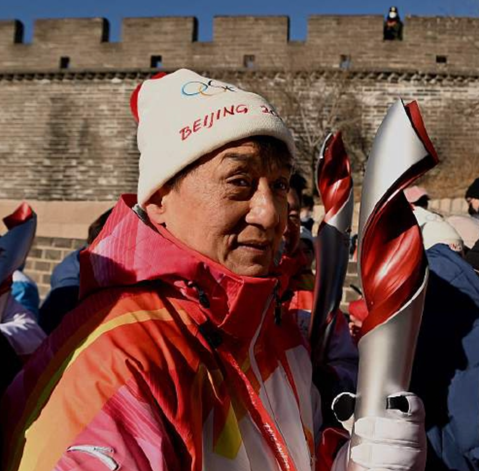 67岁成龙当冬奥运手紧抱火炬盒冻到瑟缩歪头与人合影无架子