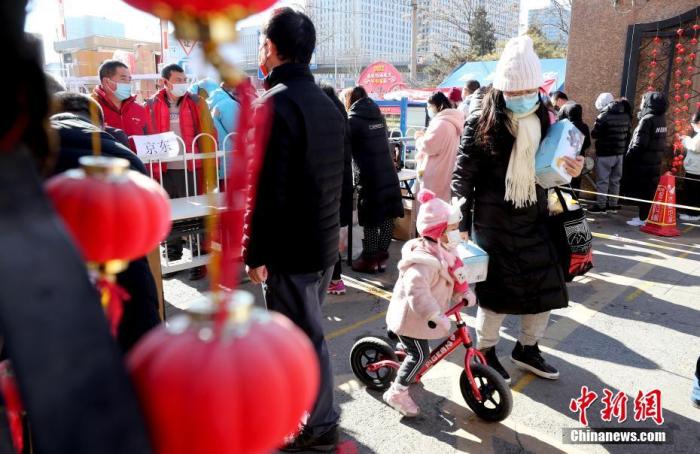 资料图:1月27日,北京丰台怡海花园居民在社区门口取快递。中新社记者 张宇 摄