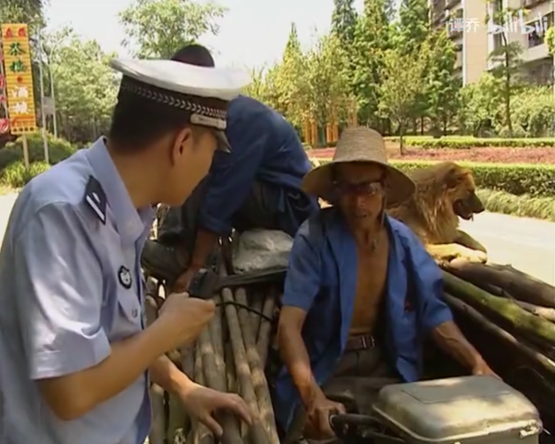 有个大爷正在用三轮车载货.2011年,谭警官在街头执法.