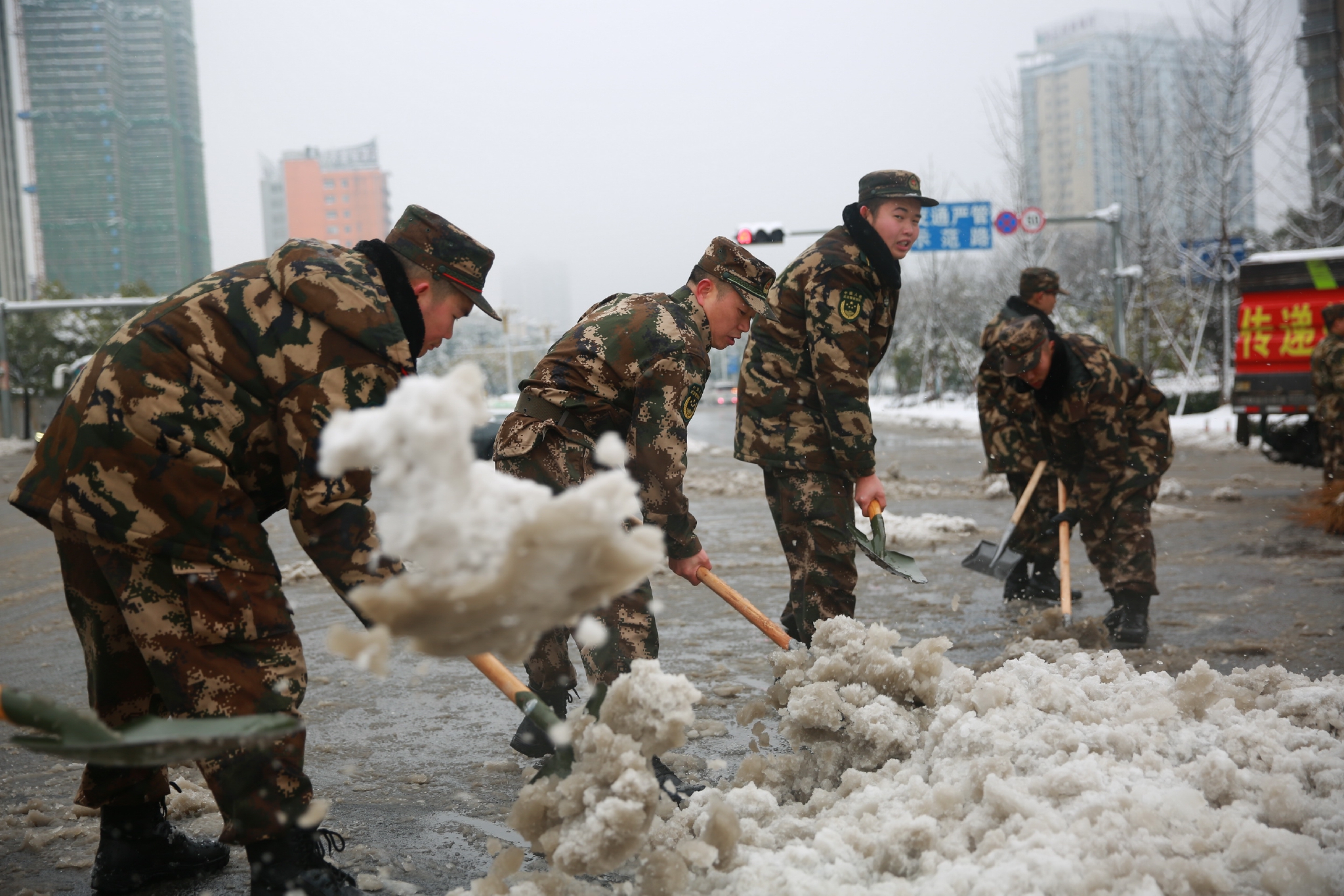 江西九江大雪武警官兵铲冰除雪保畅通