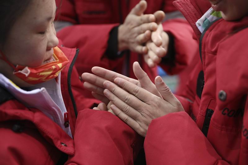 孩子们在训练结束后相互搓手取暖