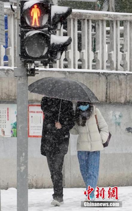 资料图：市民在风雪中出行。中新社记者 毛建军 摄