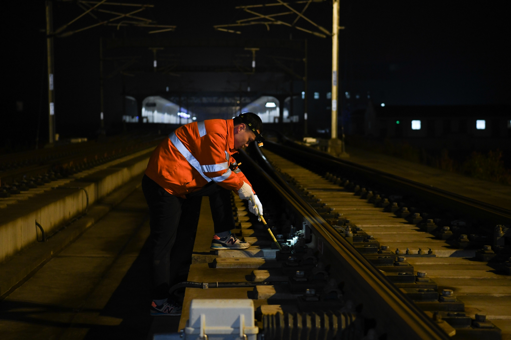 新華社記者 張端 攝2月11日,在亳州站通信機房,倪勇使用萬用表檢查