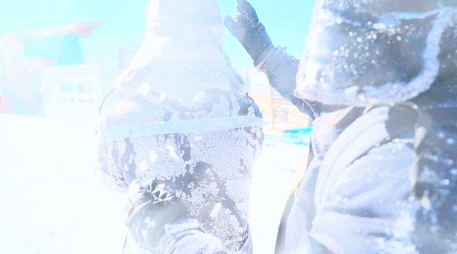 保电队员帮队友拍去身上的雪，整理装备