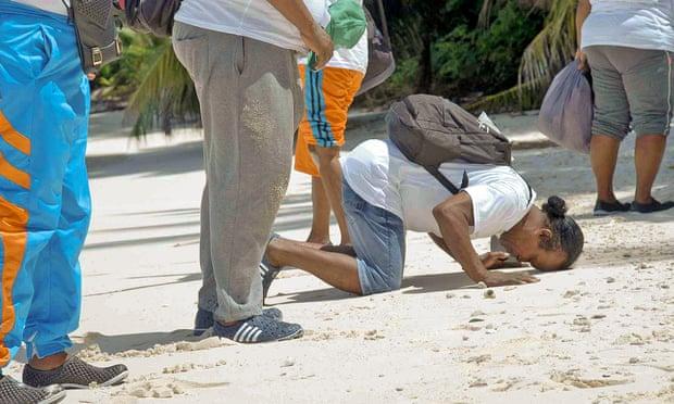 　一位查戈斯居民长跪在佩洛斯·巴纽斯环礁海滩上