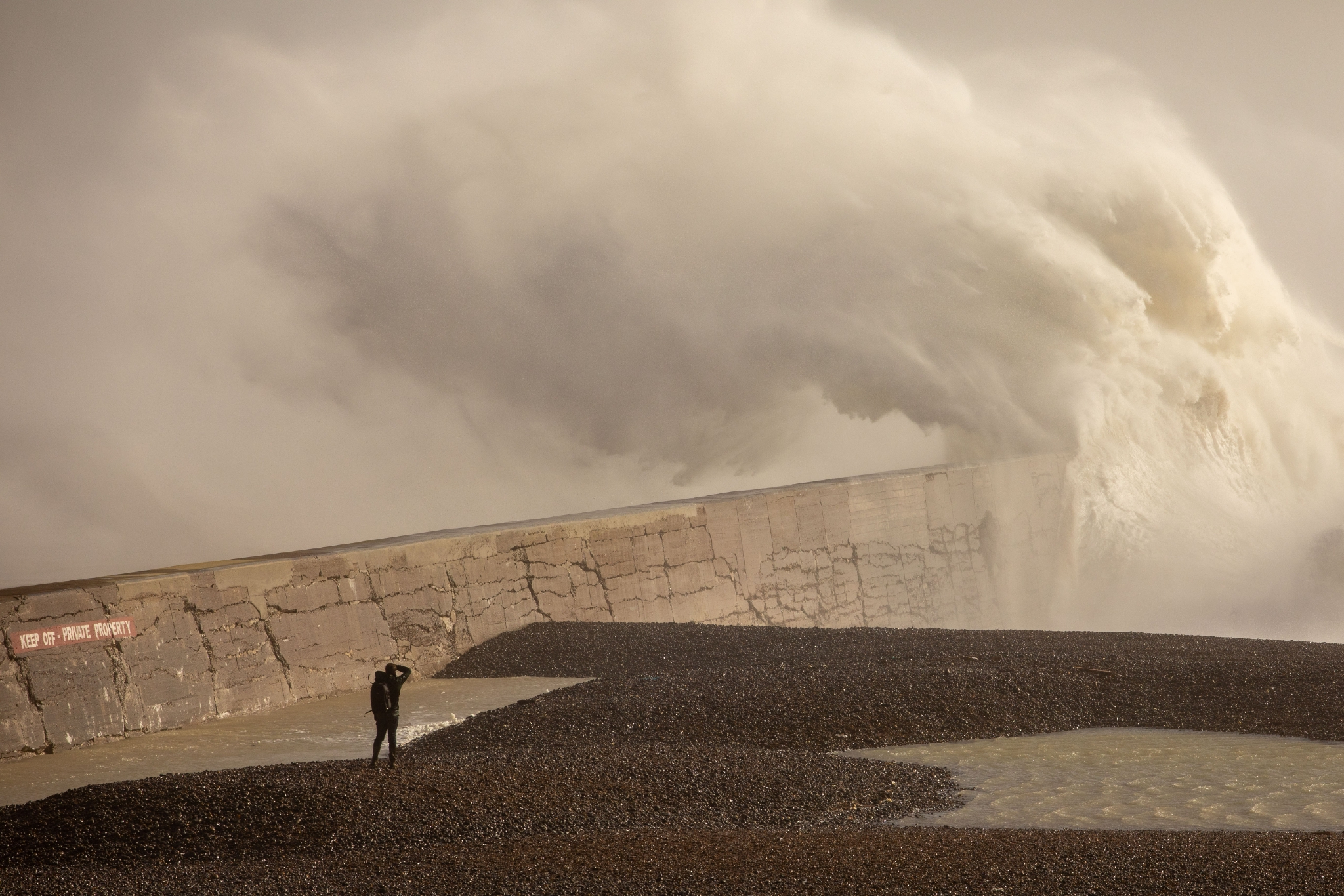 新华社发(乔恩·休珀摄)2月18日,在英国布莱克浦,一名女子逆风行走.