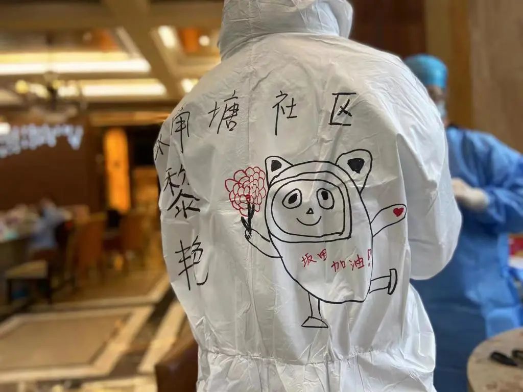 抗疫人员在防护服上画了可爱的冰墩墩,写上 " 坂田加油 !