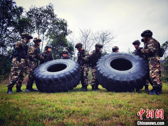 图为武警官兵正在进行抬轮胎训练. 钟炜俊 摄