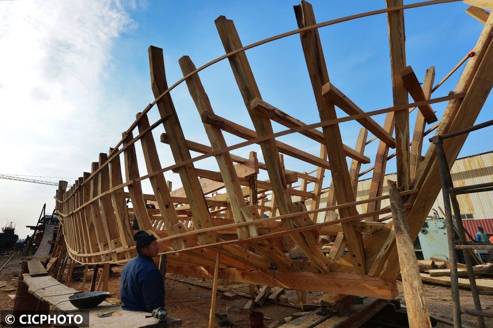 省青岛市城阳区河套街道一家渔船修造厂,一名工人在渔船龙骨上钻孔