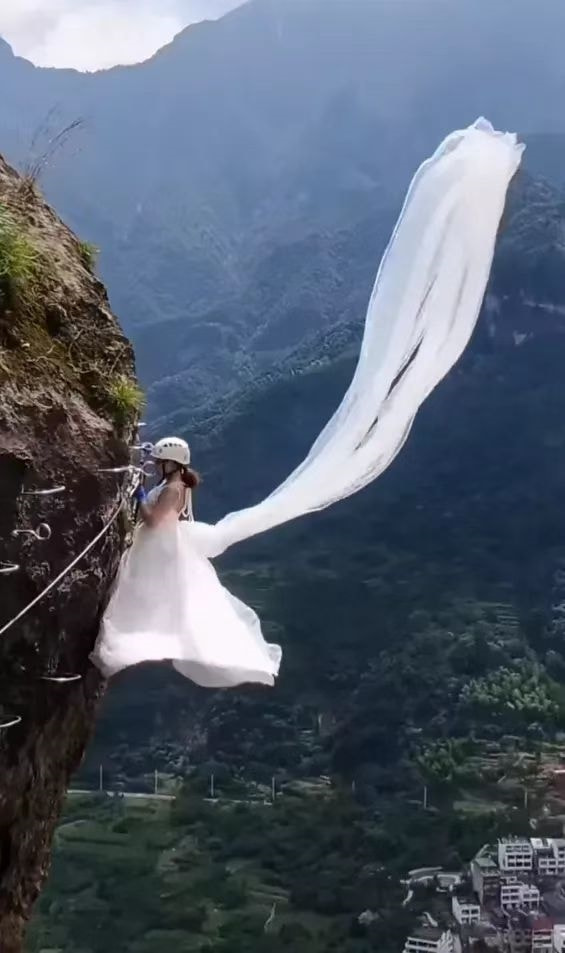 浙江一女子穿婚纱爬悬崖脚下就是万丈深渊网友看得心惊肉跳